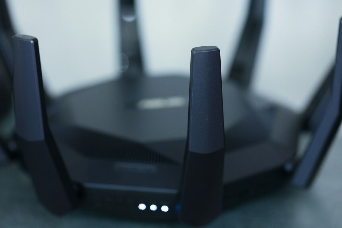 Routeur Wi-Fi noir à six antennes vu en gros plan, voyants allumés