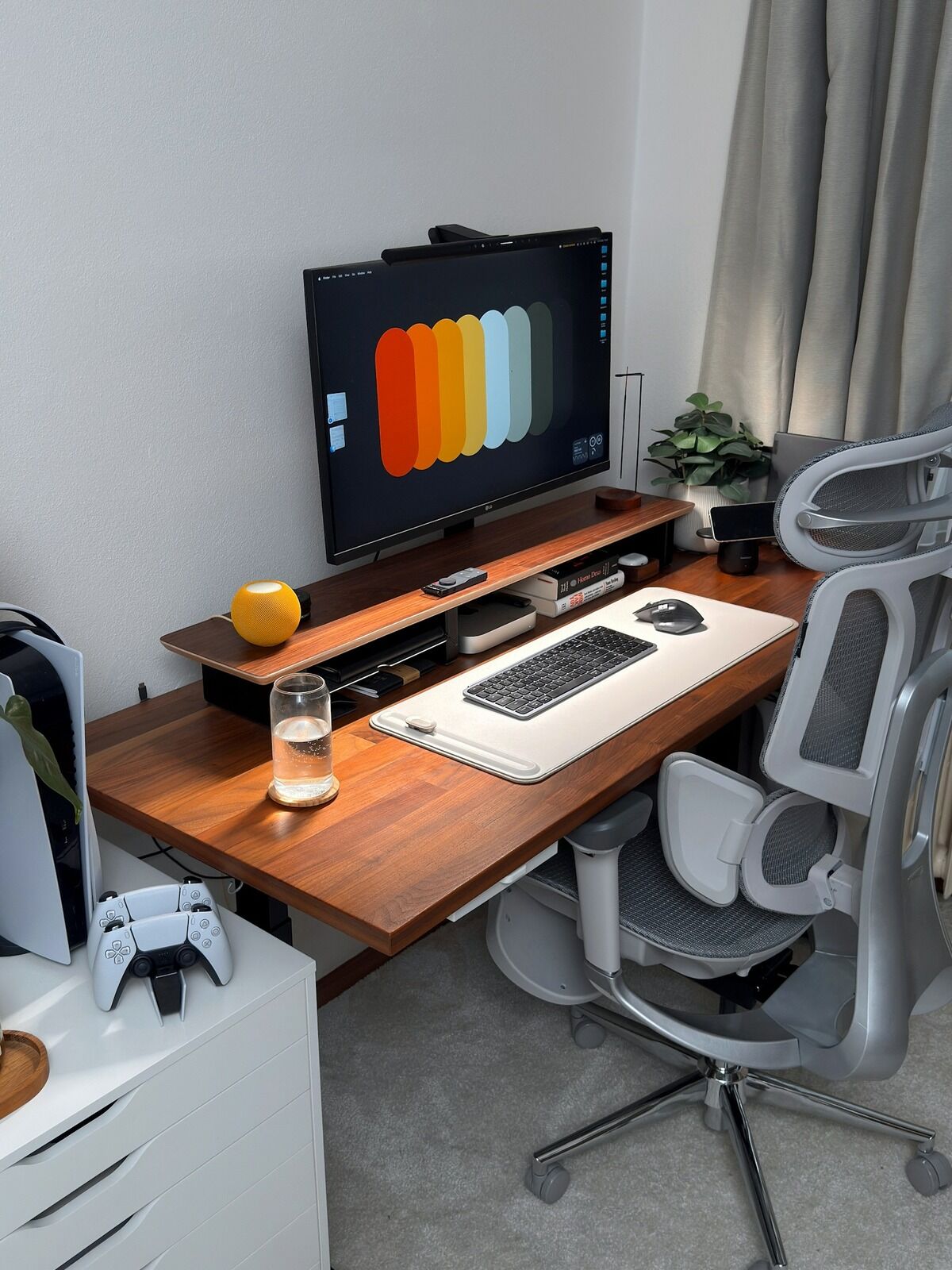 Bureau moderne avec un écran d'ordinateur, une console de jeu et des accessoires