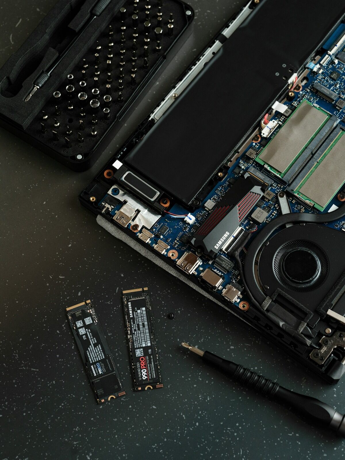Ordinateur portable ouvert par en dessous, carte mère et barrettes SSD visibles