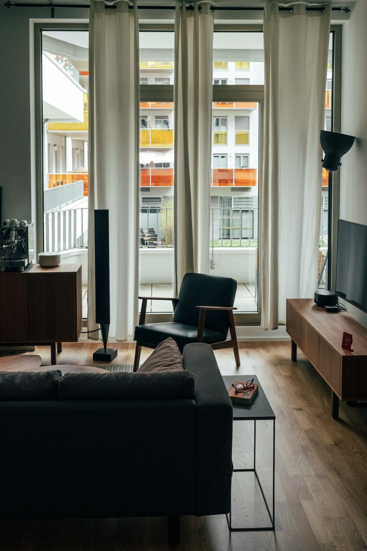 Canapé d'angle face à un téléviseur posé sur un meuble bas, dans un salon traversant