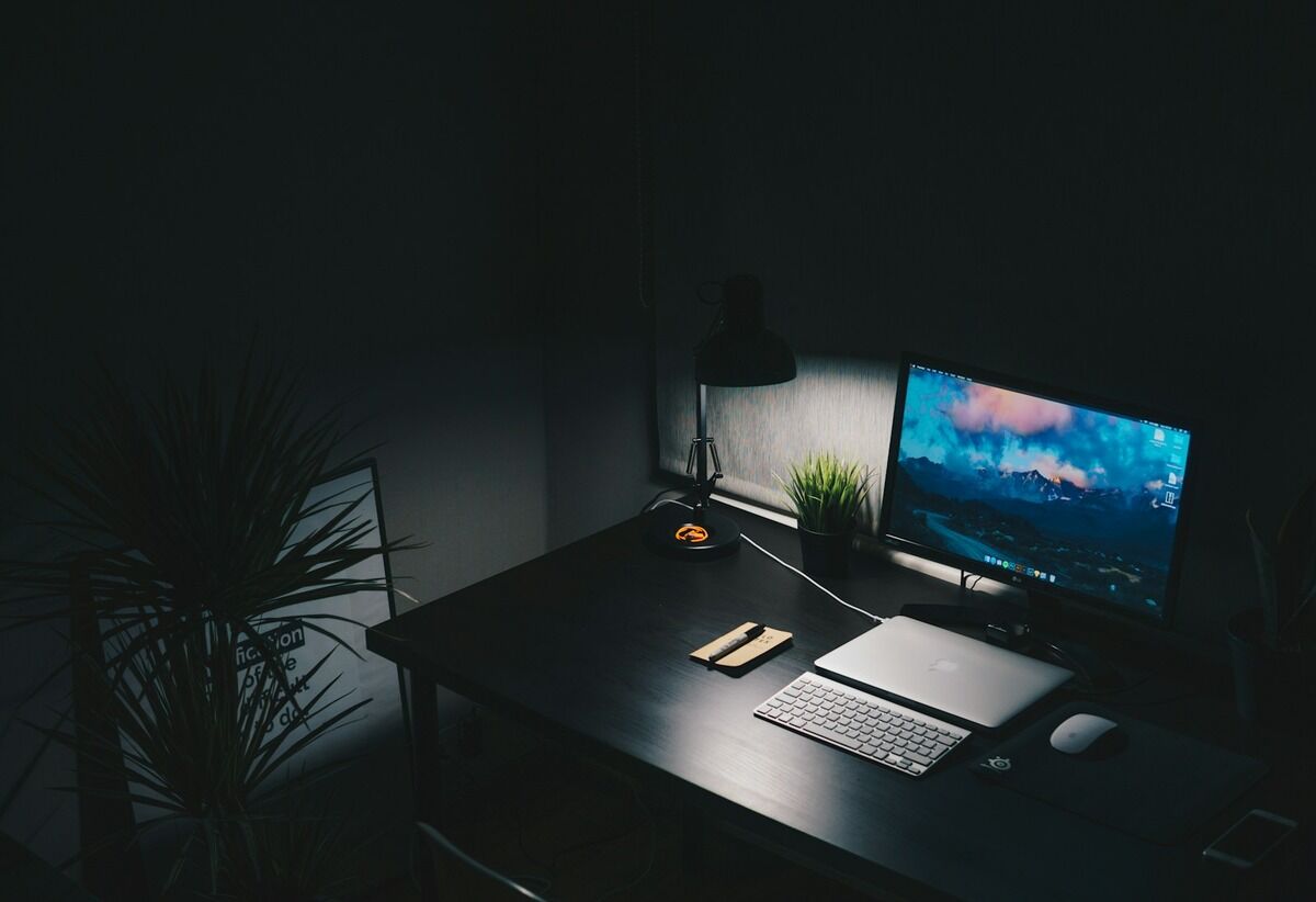 Bureau minimaliste avec un écran d'ordinateur, un clavier et un ordinateur portable