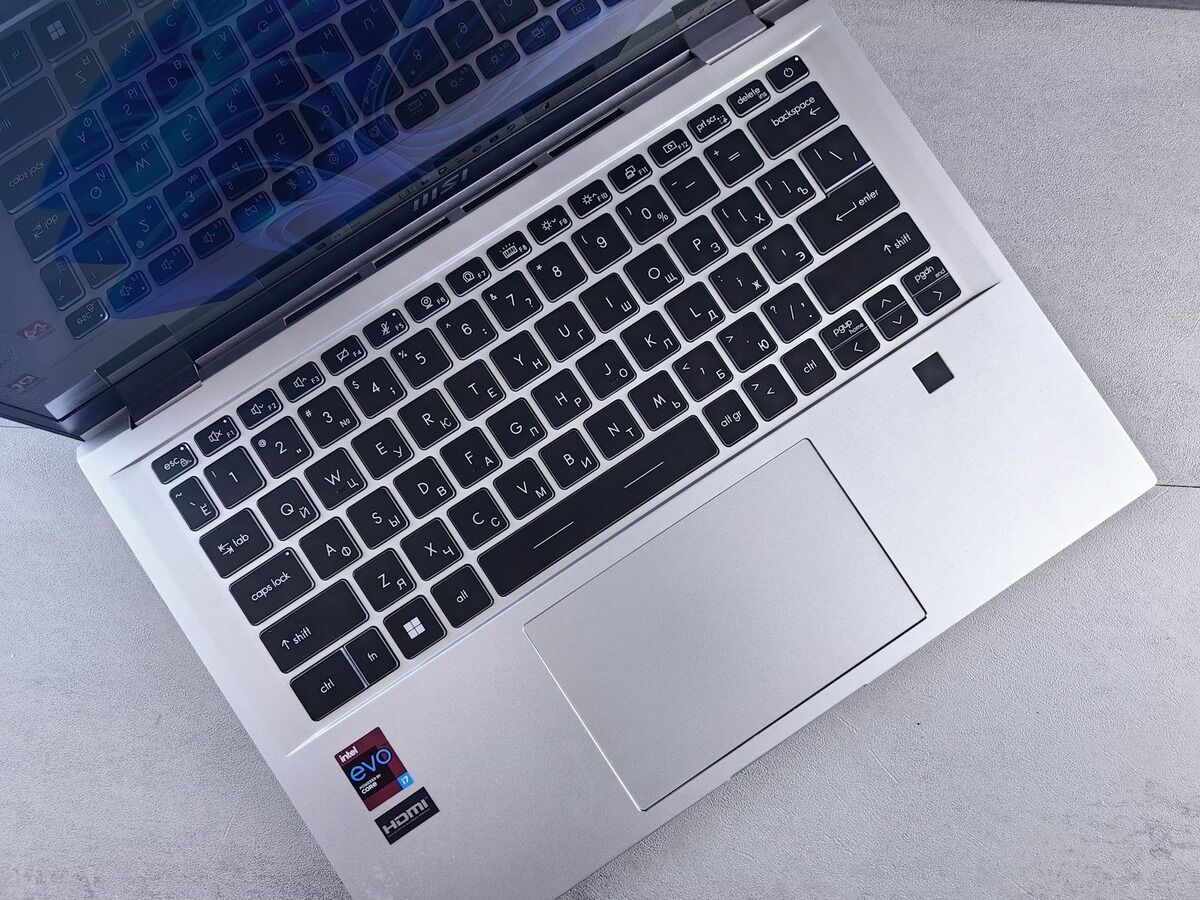 Ordinateur portable argenté ouvert, vu de trois quarts sur un plan de travail