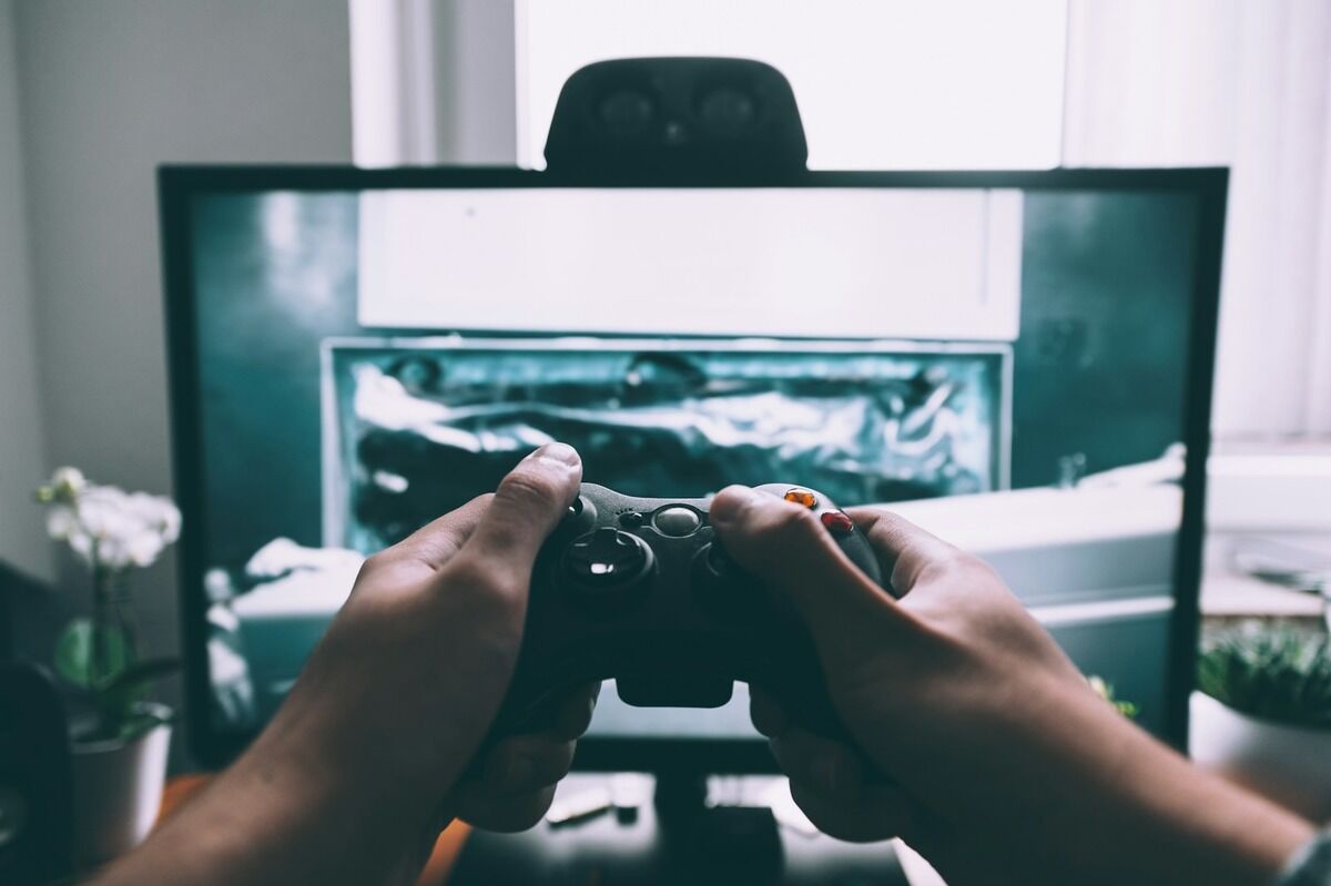 Joueur tenant une manette de console devant un téléviseur